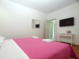 1 dormitorio con 1 cama grande con manta rosa en Ferienwohnung für 4 Personen ca 50 qm in Banjole, Istrien Istrische Riviera - b55089 en Banjole