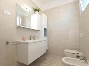 a white bathroom with a sink and a toilet at Ferienwohnung für 4 Personen ca 50 qm in Banjole, Istrien Istrische Riviera - b55089 in Banjole