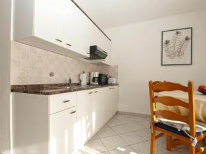 una cocina con armarios blancos y fregadero en Ferienwohnung für 4 Personen ca 48 qm in Musalež, Istrien Istrische Riviera, en Poreč