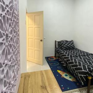 a bedroom with a bed and a white door at Nuria Padang Serai Homestay in Padang Serai