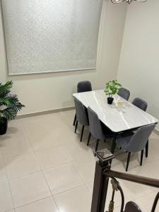 una sala da pranzo con tavolo e sedie bianchi di Lama a Riyad