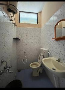uma casa de banho com um WC, um lavatório e uma janela em Serviced apartment with WiFi parking kitchen etc em Bangalore