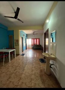 uma sala de estar com uma ventoinha de tecto e uma mesa em Serviced apartment with WiFi parking kitchen etc em Bangalore