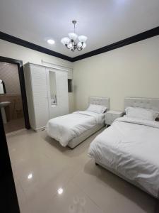um quarto com 2 camas e uma ventoinha de tecto em Lama em Riyadh