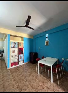 uma sala de jantar com uma mesa branca e cadeiras vermelhas em Serviced apartment with WiFi parking kitchen etc em Bangalore