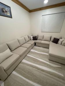 uma sala de estar com um grande sofá de secção em Lama em Riyadh