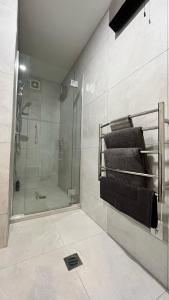 基督城的住宿－CBD Luxury 2 Bedroom Retreat，带淋浴和一些毛巾的浴室