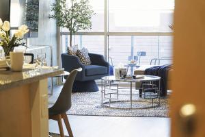 ein Wohnzimmer mit Stühlen, einem Sofa und Tischen in der Unterkunft Loft Lv8 ※ Elegant Urban Oasis in Downtown Vegas in Las Vegas