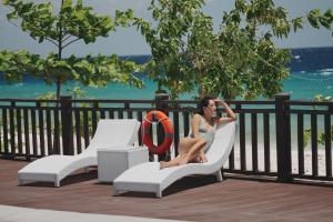 a woman in a white dress sitting on a chair at W Golf Resort in Oslob