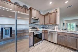 una cocina con armarios de madera y electrodomésticos de acero inoxidable en Get Close to the Action!, en Jacksonville