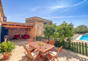eine Terrasse mit einem Tisch, Stühlen und einem Pool in der Unterkunft Ferienhaus mit Privatpool für 6 Personen ca 110 m in Campos, Mallorca Südküste von Mallorca in Campos