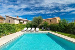 a swimming pool with lounge chairs and a house at Ferienhaus mit Privatpool für 8 Personen ca 200 qm in Kaldir, Istrien Motuvun und Umgebung in Motovun