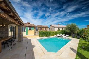 a swimming pool in a backyard with chairs and a table at Ferienhaus mit Privatpool für 8 Personen ca 200 qm in Kaldir, Istrien Motuvun und Umgebung in Motovun +14 photos