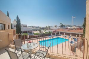 einen Balkon mit einem Tisch, Stühlen und einem Pool in der Unterkunft Studio für 3 Personen ca 1 qm in Agia Napa, Südküste von Zypern - b59036 in Ayia Napa