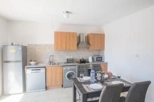 eine Küche mit einem Tisch, einem Kühlschrank und einer Spüle in der Unterkunft Studio für 3 Personen ca 1 qm in Agia Napa, Südküste von Zypern - b59036 in Ayia Napa