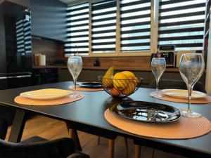 uma mesa com copos e uma taça de fruta em SeaView Lazur Apartment em Burgas