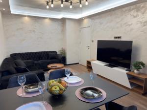 uma sala de estar com uma mesa e uma televisão em SeaView Lazur Apartment em Burgas