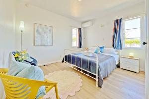 1 dormitorio con 1 cama y 1 silla en 5-Bedroom Fully-Equipped Home in Whangarei, en Whangarei