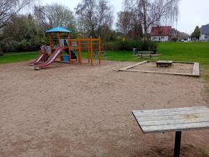 un parque infantil con un tobogán y un banco en un parque en Naza cool villa! en Malmö