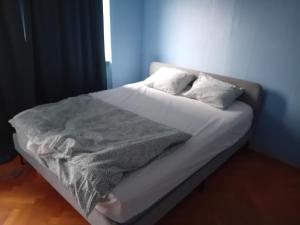 Naza cool villa! في مالمو: سرير بشرشف ووسائد بيضاء في الغرفة