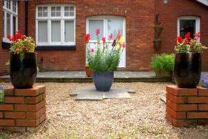 two large vases with flowers inront of a house at Gatwick Turret Guest House in Horley