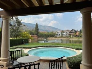 einen Pool mit Seeblick in der Unterkunft Toscana Villa Khao Yai in Pak Chong