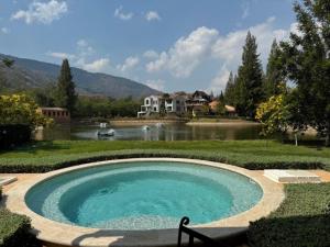basen w ogrodzie obok jeziora w obiekcie Toscana Villa Khao Yai w mieście Pak Chong