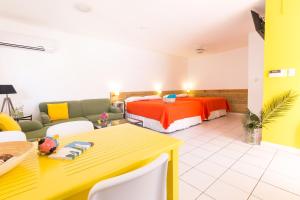 um quarto com uma cama, uma mesa e um sofá em Pauline's Apartments em Palm-Eagle Beach