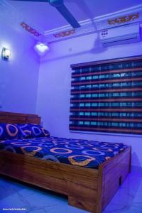 1 dormitorio con 1 cama en una habitación con luces moradas en One bedroom oluwa-sheyi-apartment, en Cotonou