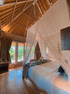 a bedroom with a bed with mosquito net at Harta Lembongan Villas in Nusa Lembongan
