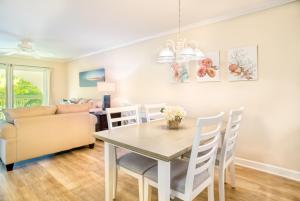a dining room with a table and a couch at Breakers West C1 condo in Sanibel