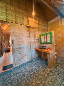 a bathroom in a house with a wooden wall at Harta Lembongan Villas in Nusa Lembongan