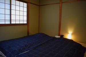 高山的住宿－Komorebi/こもれび，一间卧室设有蓝色的床和2个窗户。