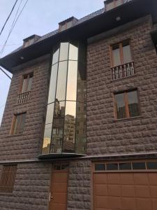 Un edificio con un reflejo de la ciudad en la ventana. en Asana Tourism and Business, en Ereván