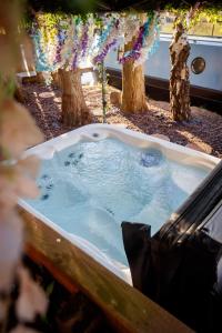 eine Badewanne mit Wasser, Bäumen und Blumen in der Unterkunft Haw thorn Hideaway in Doncaster