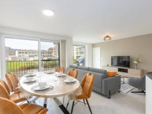 a living room with a table and a couch at Corner apartment in the center with 3 bedrooms in Middelkerke