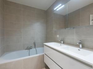 a bathroom with a tub and a sink and a bath tub at Corner apartment in the center with 3 bedrooms in Middelkerke +17 photos