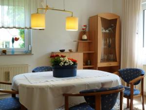 a dining room table with chairs and a pot of flowers on it at Black Modern Retreat 