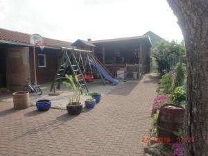 un parque infantil con tobogán y macetas en un patio en Pilsterhill Modern Retreat, en Oberleichtersbach