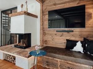 a living room with a couch and a fireplace at Chalet Nordic Modern Retreat in Bayrischzell
