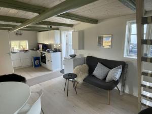a living room with a couch and a kitchen at Ocean View Modern Retreat in Neksø