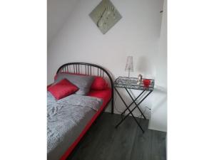 Una cama con almohadas rojas y una mesa en una habitación en Modern retreat by the lake, en Olsberg