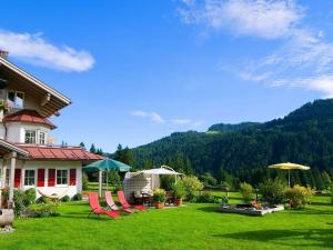 a yard with chairs and umbrellas in front of a house at 2 in Alpenrösle Modern retreat in Balderschwang