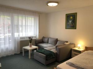 ein Wohnzimmer mit einem Sofa und einem Bett in der Unterkunft Family Apartment Bavaria in Füssen