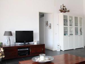 a living room with a tv and a table at Friesche Zusje on the IJsselmeer in Makkum