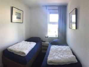1 dormitorio con 2 camas y ventana en Friesche Zusje on the IJsselmeer, en Makkum