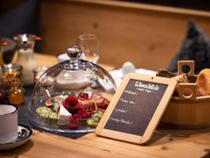 a plate of food in a glass dome on a table at Alpglück Chalet Modern retreat in Oberstdorf