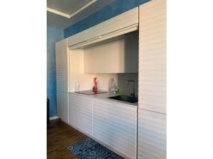 a kitchen with white cabinets and a sink at The Sarzana Suite in Sarzana