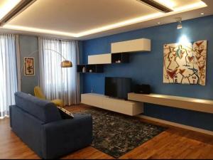 een woonkamer met een blauwe muur en een televisie bij The Sarzana Suite in Sarzana