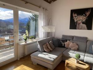a living room with a couch and a large window at Villa Alpenblick Comfortable holiday residence in Füssen